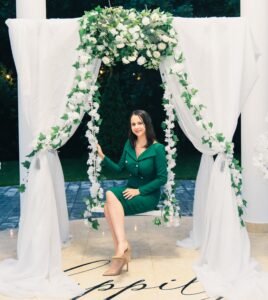 Photocorner cu leagăn decorativ pentru evenimente, ideal pentru fotografii la nuntă, botez sau petrecere, cu flori și lumini ambientale.