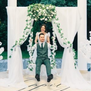 Photocorner cu leagăn decorativ pentru evenimente, ideal pentru fotografii la nuntă, botez sau petrecere, cu flori și lumini ambientale.